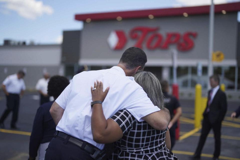 Two people embrace in front of the Tops supermarket in Buffalo, N.Y.