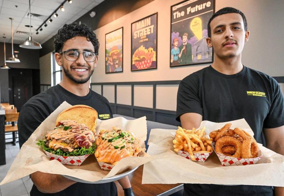 Khalid Abdulqawai, left, and his brother Omar hold up some of the bites available at their new restaurant, Main Street Burgers, in the Marketplace at El Paseo in northwest Fresno.
