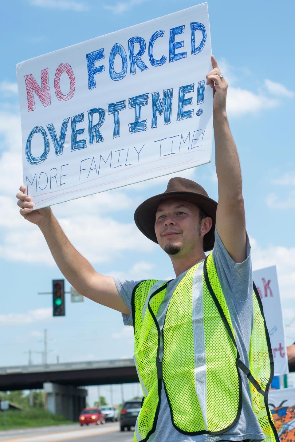 Monk Drapeaux-Stewart holds a sign reflecting compromising work-life balance during a strike against Frito-Lay outside of the plant in Topeka, Kansas Tuesday 13 July 13 2021. (AP)