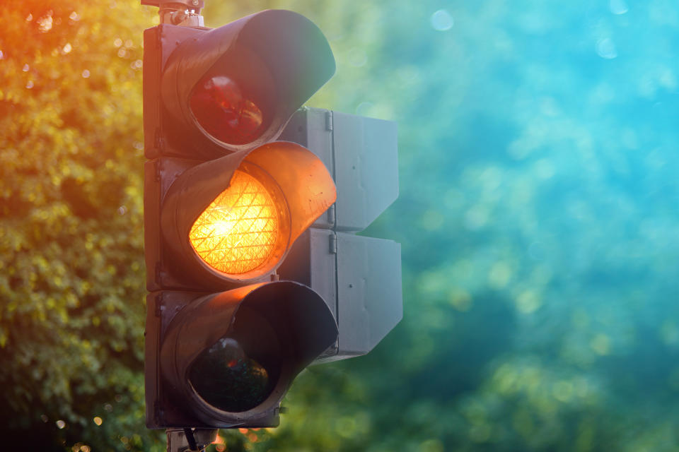 Yellow light of traffic lights in summer city