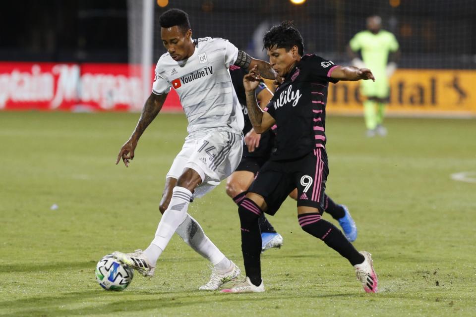 Seattle Sounders forward Raul Ruidiaz and LAFC midfielder Mark-Anthony Kaye compete for the ball.