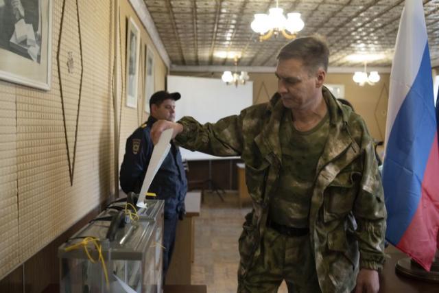 Un militar vota en un colegio electoral en Lugansk, República Popular de Lugansk, controlada por los separatistas apoyados por Rusia, en el este de Ucrania, el viernes 23 de septiembre de 2022.