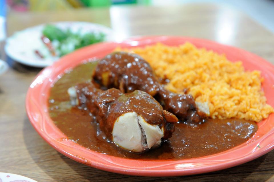 Rich, spiced and slightly sweet homemade molé on boiled chicken with rice at Nachos Grill on Saturday, Jan. 22, 2022.