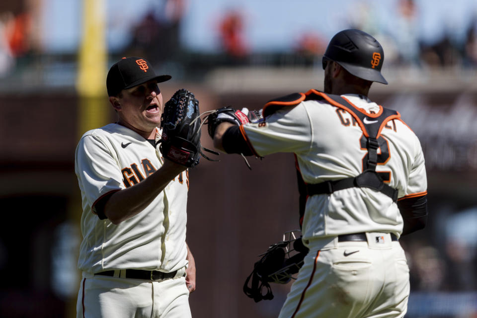 San Francisco Giants relief pitcher Jake McGee, left, and catcher Curt Casali celebrate after the Giants defeated the Texas Rangers 4-2 in a baseball game in San Francisco, Tuesday, May 11, 2021. (AP Photo/John Hefti)