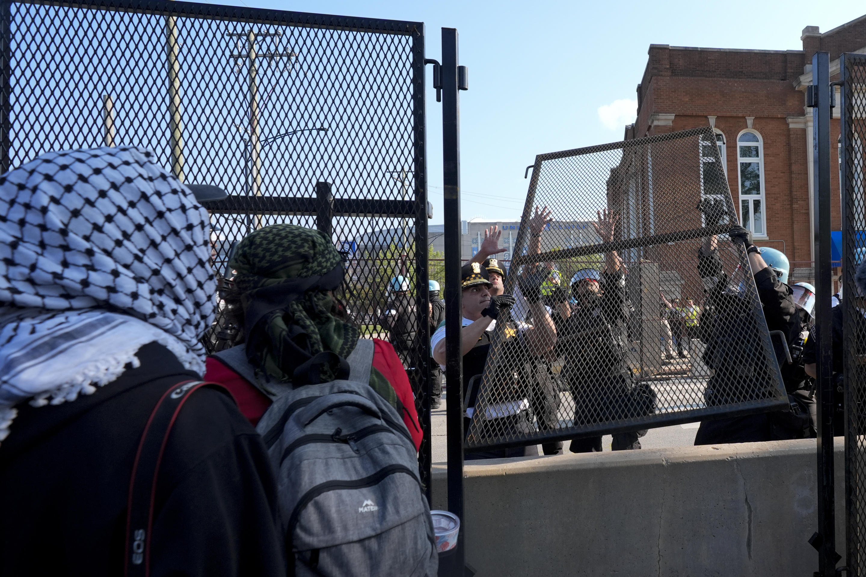 Police replace a section of fence that was torn down by protesters outside the United Center in Chicago on Monday. (Frank Franklin II/AP)