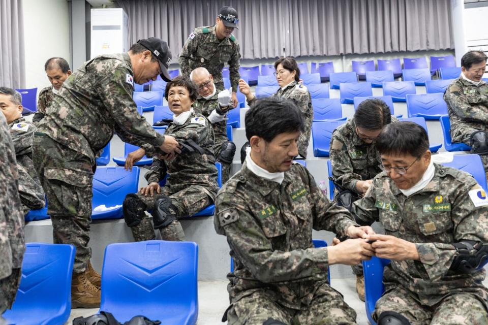 Members of the Senior Army put on protective gear during military training at the Infantry Reserve