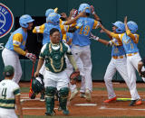 South Korea catcher Gi Jeong Kim, walks to the mound as Honolulu, Hawaii's Mana Lau Kong (19) is greeted by teammates after hitting the first pitch of the baseball game from South Korea's Yeong Hyeon Kim, lower left, for a solo home run in the first inning of the Little League World Series Championship in South Williamsport, Pa., Sunday, Aug. 26, 2018. (AP Photo/Tom E. Puskar).