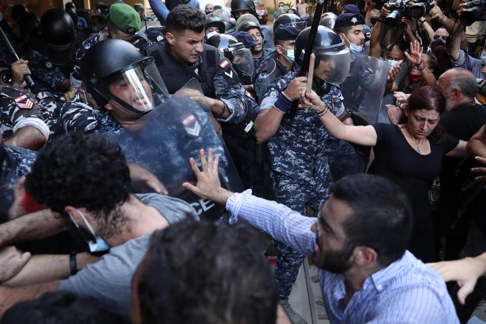 Relatives of people who were killed in last year's massive blast at Beirut's seaport scuffle with riot police as they try to storm the home of caretaker Interior Minister Mohamed Fehmi in Beirut, Lebanon, Tuesday, July 13, 2021. Family members are angry with Fehmi because he rejected a request by the judge investigating the explosion to question Maj. Gen. Abbas Ibrahim, who is one of Lebanon's most prominent generals and heads of the General Security Directorate. (AP Photo/Bilal Hussein)