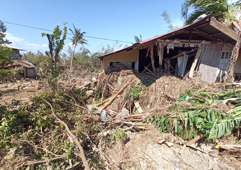 Debris from floods caused by Typhoon Phanfone surround a damaged house in Balasan Town, Iloilo province, central Philippines on Thursday Dec. 26, 2019. A strong typhoon that barreled through the central Philippines left at least 20 people dead and forced thousands to flee their homes, devastating Christmas celebrations in the predominantly Catholic country. (AP Photo/Leo Solinap)