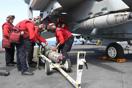 Flight deck crew remove ordnance from an F/A-18E Super Hornet on the flight deck of the aircraft carrier USS Abraham Lincoln (CVN 72), in Arabian Sea, May 22, 2019. Picture taken May 22, 2019. Matt Herbst/U.S. Navy/Handout via REUTERS