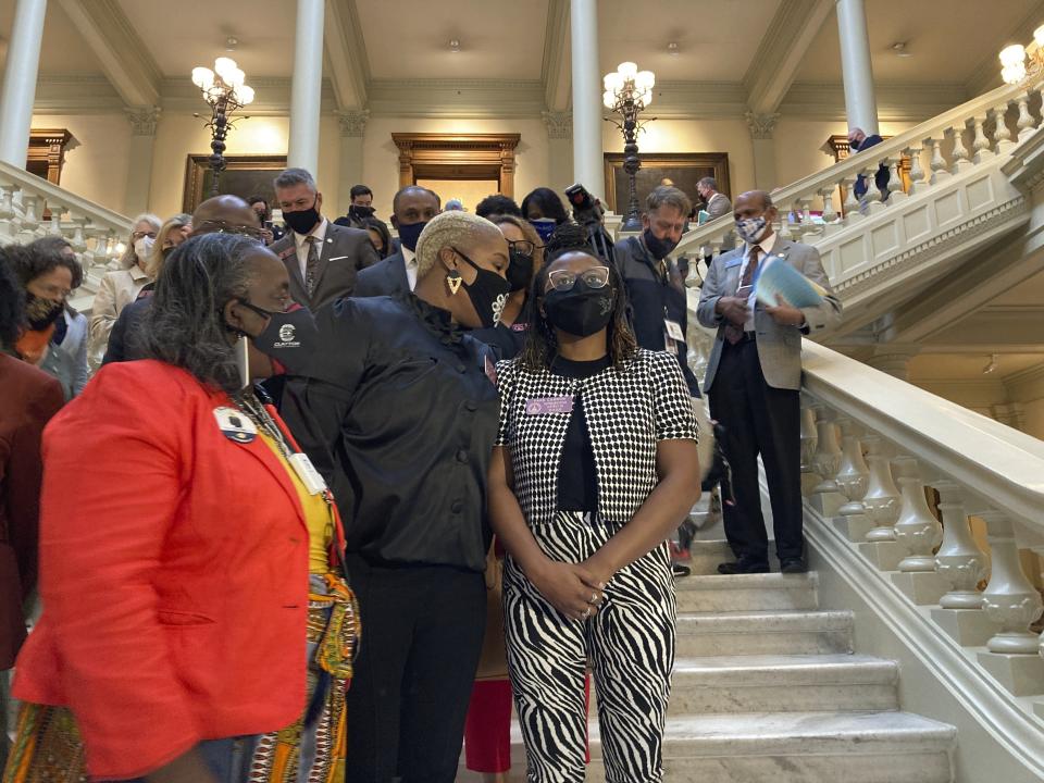 FILE - In this Friday, Feb. 26, 2021 file photo, Georgia House Democrats speak with Democratic Rep. Park Cannon, right, in Atlanta during a sit-in at the state capitol sparked by opposition to Republican proposals that would restrict voting. On Friday, March 5, 2021, The Associated Press reported on a video circulating online incorrectly asserting left-wing protesters stormed Georgia’s Capitol building in Atlanta or engaged in an insurrection over a bill that would require photo ID for absentee voting. However, the Georgia Department of Public Safety confirmed to the AP that the protesters entered the state Capitol lawfully and remained peaceful, unlike the rioters in the violent Jan. 6 insurrection in Washington. “No one was arrested,” spokesperson Franka Young wrote. (AP Photo/Jeff Amy)