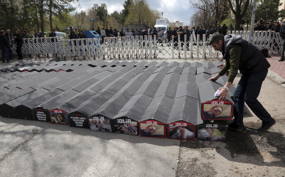 Miembros de un sindicato turco colocan ataúdes frente a la embajada rusa, protegida por agentes antimotines, como protesta contra el ataque del gobierno sirio con armas químicas que dejó más de 80 muertos en el norte de Siria. En Ankara, Turquía, viernes 7 de abril de 2017. (AP Foto/Burhan Ozbilici)