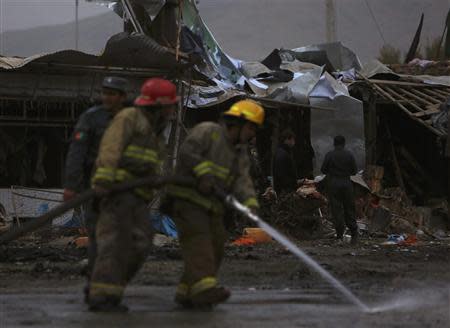 Firemen hose down an area at the site of a suicide blast in Kabul, November 16, 2013. REUTERS/Mohammad Ismail