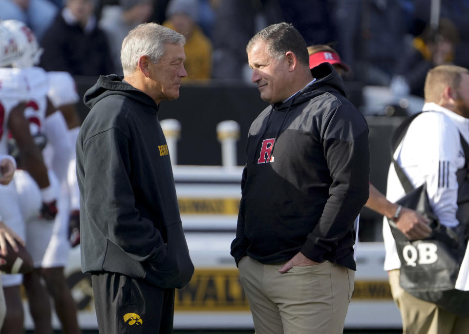 Iowa head football coach Kirk Ferentz, center left, visits with Rutgers head football coach Greg Schiano, center right, prior to an NCAA college football game, Saturday, Nov. 11, 2023, in Iowa City, Iowa. (AP Photo/Bryon Houlgrave)