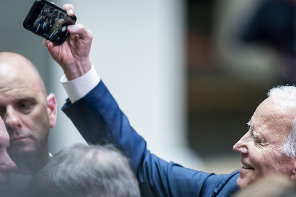 US President Joe Biden takes selfies with members of the audience after delivering his keynote speech at Ulster University in Belfast Wednesday, April 12, 2023 during his visit to the island of Ireland. (Aaron Chown/PA via AP)