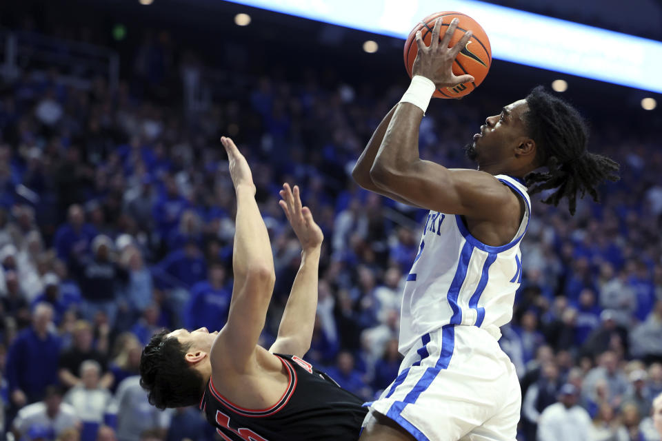 Kentucky's Antonio Reeves, right, shoots while defended by Georgia's RJ Melendez during the first half of an NCAA college basketball game Saturday, Jan. 20, 2024, in Lexington, Ky. (AP Photo/James Crisp)