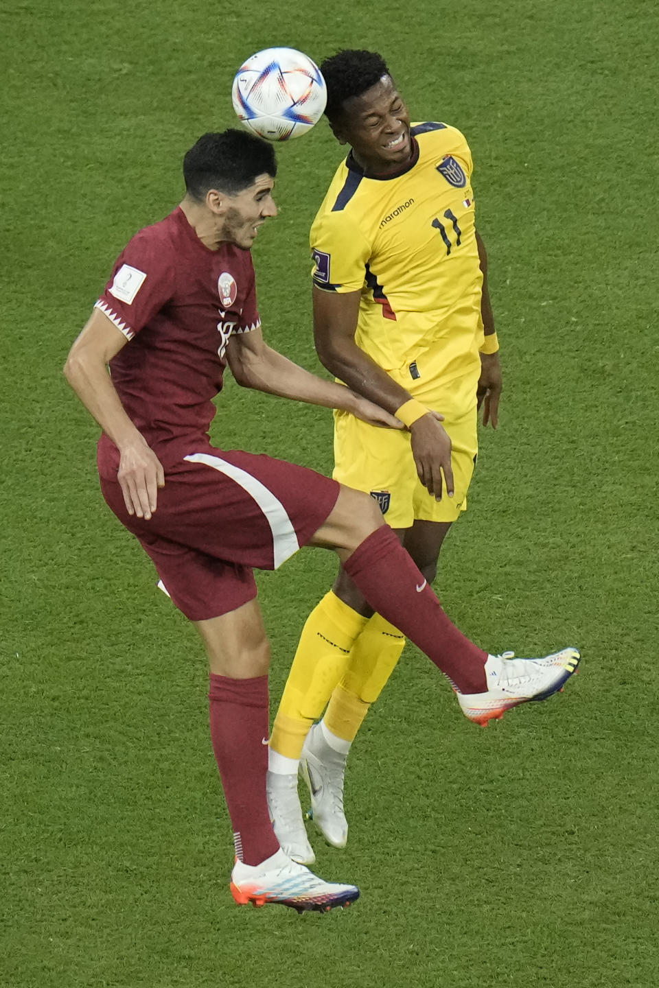Karim Boudiaf de Qatar, a la izquierda, y Michael Estrada de Ecuador disputan el balón durante el partido inaugural de la Copa Mundial en el estadio Al Bayt en Al Khor, Qatar, el domingo 20 de noviembre de 2022. (Foto AP/Hassan Ammar)