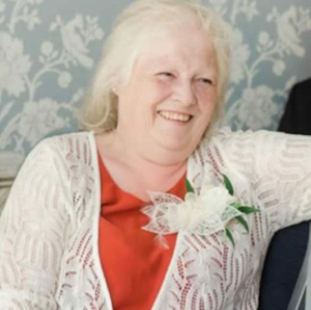 A woman with white hair wearing an orange dress