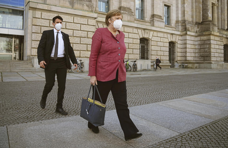 Chancellor Angela Merkel goes to her car after the session of the Bundestag in Berlin, Germany, Wednesday, April 21, 2021. The topic is the 2nd/3rd reading on the amendment of the Infection Protection Act, followed by a vote on the bill. (Michael Kappeler/dpa via AP)