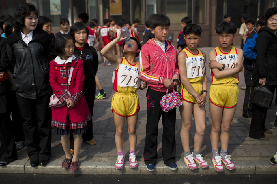 Young North Korean runners rest after finishing their part of the Mangyongdae Prize International Marathon in Pyongyang, North Korea on Sunday, April 13, 2014. The annual race, which includes a full marathon, a half marathon, and a 10-kilometer run, was open to foreign tourists for the first time this year. (AP Photo/David Guttenfelder)