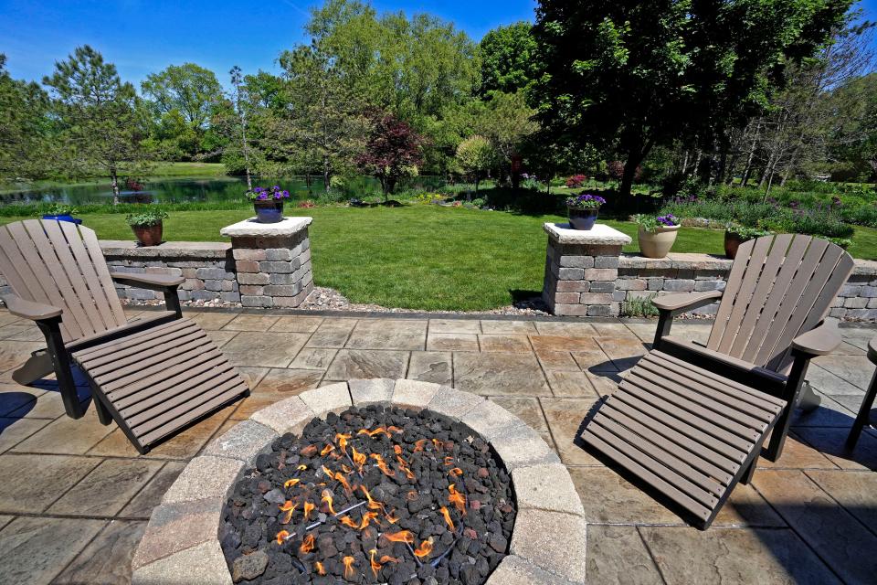 The deck at the back of the house of Casey and Kathie Palmisano, pictured on May 26, 2023, has a fire pit and overlooks the gardens and pond.