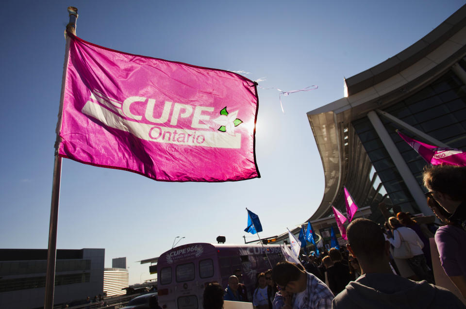 A person holds a flag with the logo of the Canadian Union for Public Employees (CUPE), which represents flight attendants from Air Canada, during a protest about labour disputes at the Toronto Pearson International Airport in Toronto, September 20, 2011. Labour talks between Air Canada and its unionized flight attendants will resume later on Tuesday with both sides expressing hope that a last-minute deal was still within reach. The CUPE, which represents Air Canada's 6,800 flight attendants, organized rallies at airports across Canada on Tuesday, some 14 hours ahead of a possible strike. REUTERS/Mark Blinch (CANADA - Tags: BUSINESS TRANSPORT CIVIL UNREST EMPLOYMENT)