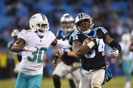Nov 13, 2017; Charlotte, NC, USA; Carolina Panthers running back Cameron Artis-Payne (34) with the ball as Miami Dolphins cornerback Cordrea Tankersley (30) defends in the fourth quarter. The Panthers defeated the Dolphins 45-21 at Bank of America Stadium. Bob Donnan-USA TODAY Sports