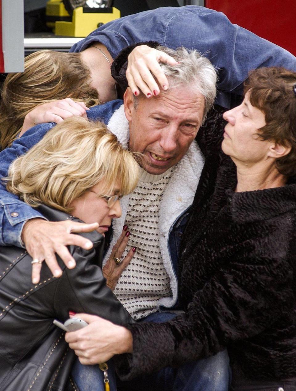 Dennis Zafuto ia embraced by friends after he learned that his wife Marilyn Frost-Zafuto was killed in the collapse of the Acorn building during the San Simeon Earthquake Paso Robles, Dec. 22, 2003.