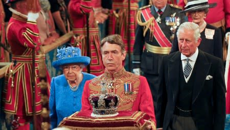 FILE PHOTO: Britain's Queen Elizabeth and Prince Charles walk through the Royal Gallery during the State Opening of Parliament in central London