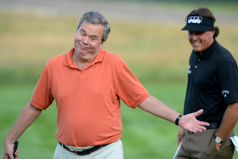 Former Florida Gov. Jeb Bush reacts in front of golfer Phil Mickelson after making a putt in The Barclays Pro-Am golf tournament at Bethpage State Park in Farmingdale, N.Y., Wednesday, Aug. 22, 2012. (AP Photos/Henny Ray Abrams)