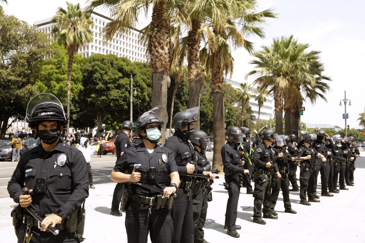 Los Angeles police officers stand by after advocates against vaccine mandates and pro-vaccine advocates confronted each other in front of City Hall in downtown Los Angeles on Aug. 14, 2021. 