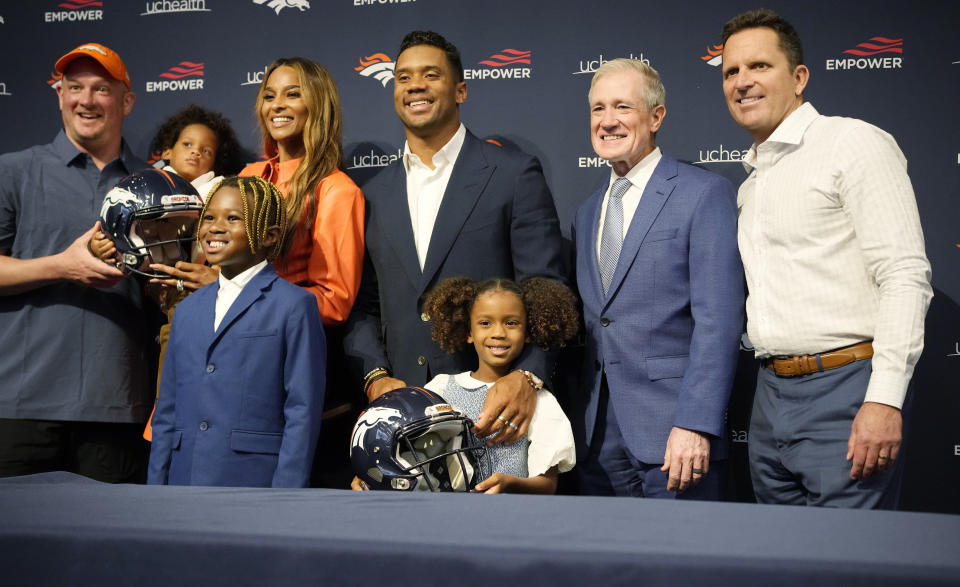 Denver Broncos quarterback Russell Wilson, center, is joined by team officials, his family and agent for a photograph after a news conference to announce that Wilson had signed a five-year-contract extension worth $245 million, at the NFL football team's headquarters Thursday, Sept. 1, 2022, in Centennial, Colo. With Wilson are, from left, Broncos coach Nathaniel Hackett, Wilson's son Win, wife and rap star Ciara, stepson Future, daughter Sienna, agent Mark Rodgers and Broncos general manager George Paton. (AP Photo/David Zalubowski)