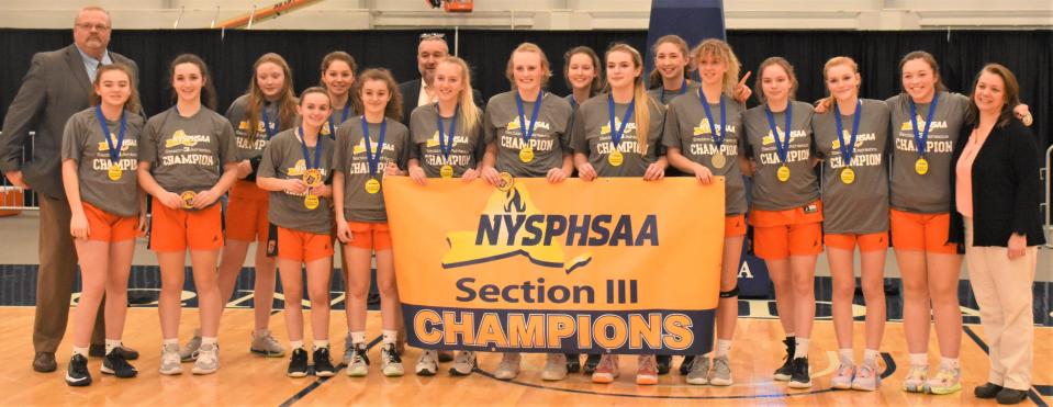 The Cooperstown Hawkeyes pose with their banner after beating Weedsport Saturday in Section III's Class C final at SRC Arena.