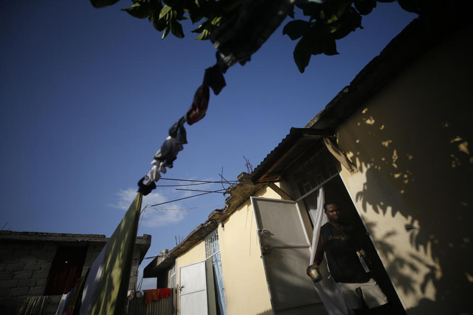 Entrepreneur and youth leader Pascéus Juvensky St. Fleur, 26, leaves his house carrying paints as he prepares to work on a multimedia painting, in Delmas neighborhood of Port-au-Prince, Haiti, Tuesday, Oct. 8, 2019. St. Fleur says the protests are not only about replacing a president, but changing a system. "It's not one person, it's not one regime, it's not a president, it's not the opposition, it's not the bourgeoisie, but it's us who should do it," he said. "We dream of, and we want, a better Haiti."(AP Photo/Rebecca Blackwell)