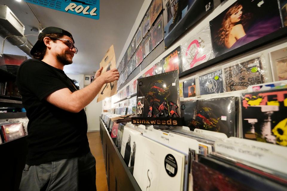 Stinkweeds employee Zach Willekens stocks a new album at the Phoenix record store on July 12 2023, while an expansion project is underway.