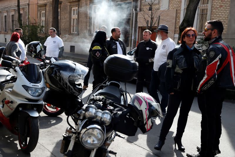 Members of the 'Easy Riders', a Hungarian bikers group, talk as they help a domestic violence victim in Budapest