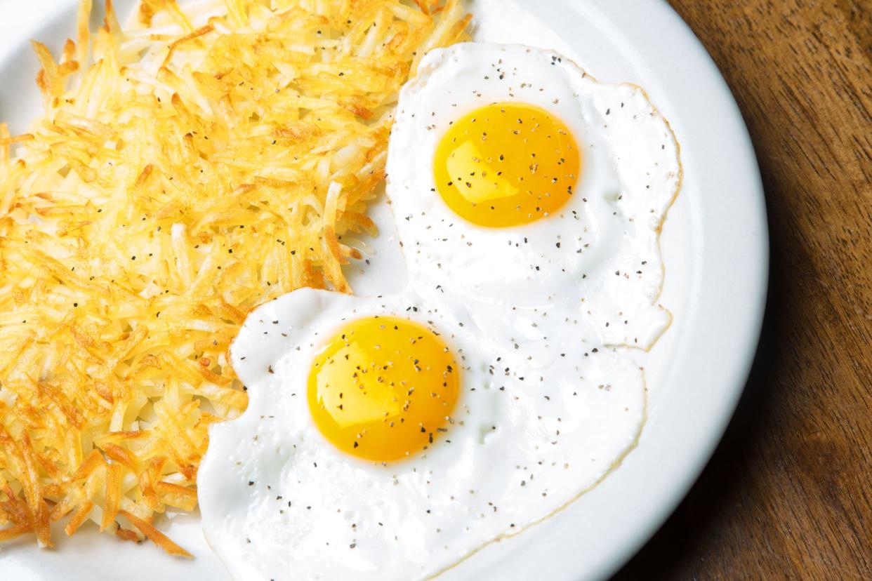 Breakfast of sunny side up eggs and hash browns.