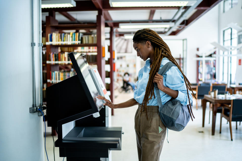 A woman at a computer in a library