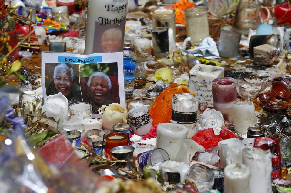 Candles and photos of former South African President Nelson Mandela are placed outside of Mandela's house in Johannesburg December 15, 2013. South Africa buries Nelson Mandela on Sunday, closing one momentous chapter in its tortured history and opening another in which the multi-racial democracy he founded will have to discover if it can thrive without its central pillar. REUTERS/Yves Herman (SOUTH AFRICA - Tags: OBITUARY POLITICS)