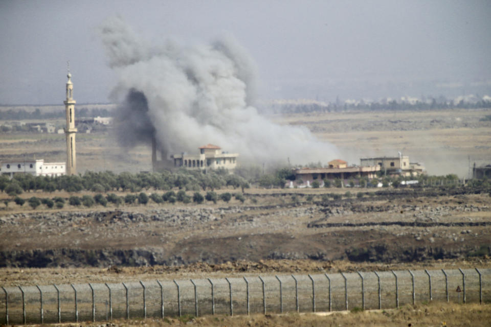 Smoke and explosions from the fighting between forces loyal to Syrian President Bashar Assad and rebels in the Darra province can be seen from the Israeli-controlled Golan Heights, Wednesday, July 25, 2018. (AP Photo/Ariel Schalit)