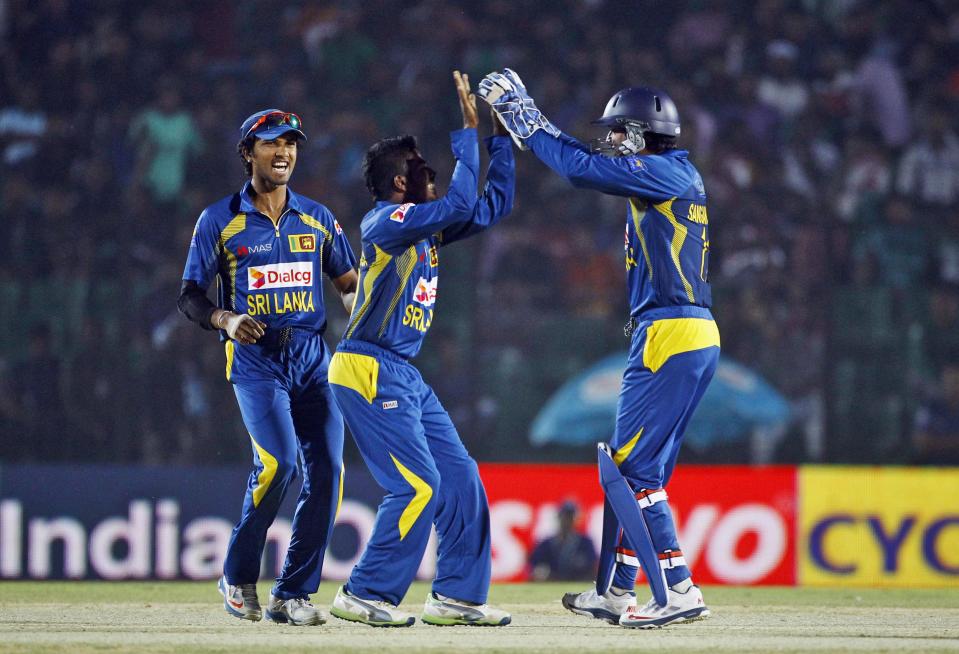 Sri Lanka’s Chaturanga de Silva, center, celebrates the wicket of Pakistan’s Ahmed Shehzad with teammates during the opening match of the Asia Cup one-day international cricket tournament between them in Fatullah, near Dhaka, Bangladesh, Tuesday Feb. 25, 2014. (AP Photo/A.M. Ahad)