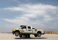 A forklift carries a vehicle in Bagram U.S. air base, after American troops vacated it, in Parwan province