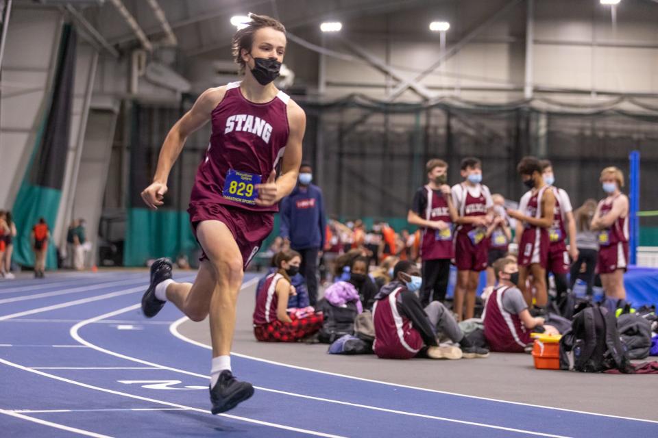 Bishop Stang’s Luke Grigson takes the turn in the 300 meters on Thursday at Wheaton College.