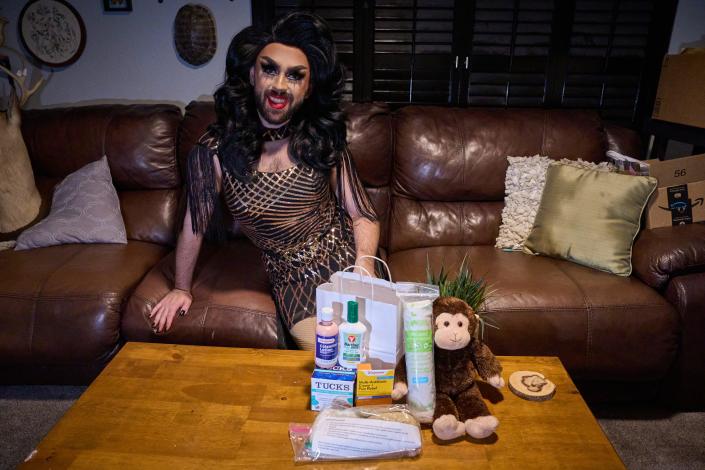 Phoenix drag queen Trey poses for a portrait in her home with the care kit she's giving away to people dealing with monkeypox symptoms on Aug. 29, 2022.