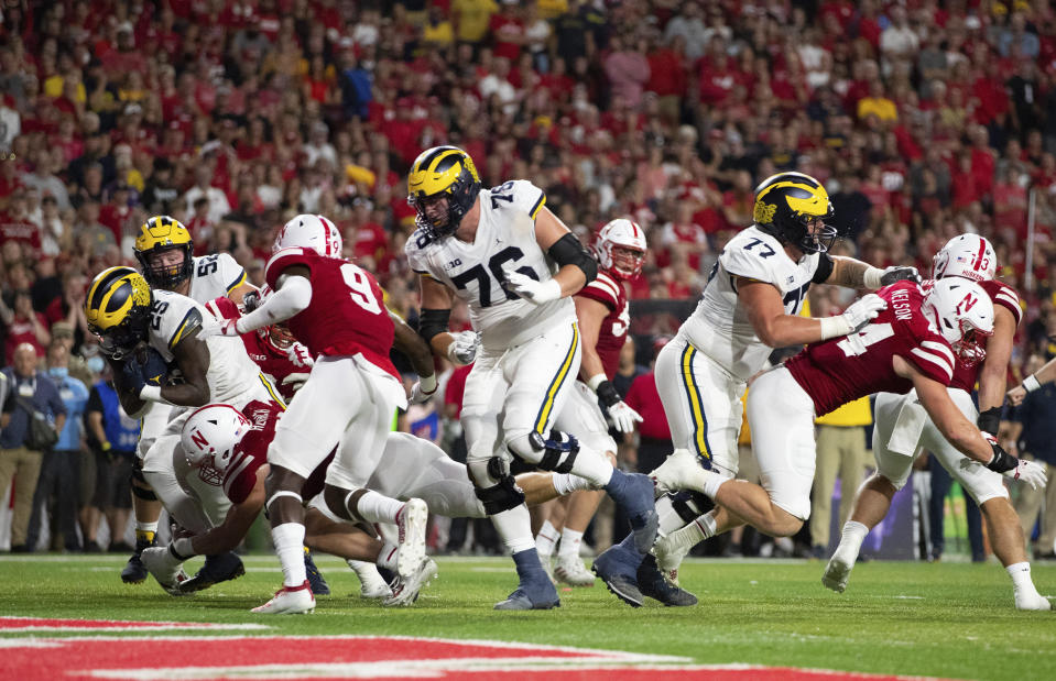 Michigan's Hassan Haskins, left, runs in for a touchdown against Nebraska linebacker Nick Henrich (42) during the second half of an NCAA college football game Saturday, Oct. 9, 2021, in Lincoln, Neb. (AP Photo/Rebecca S. Gratz)