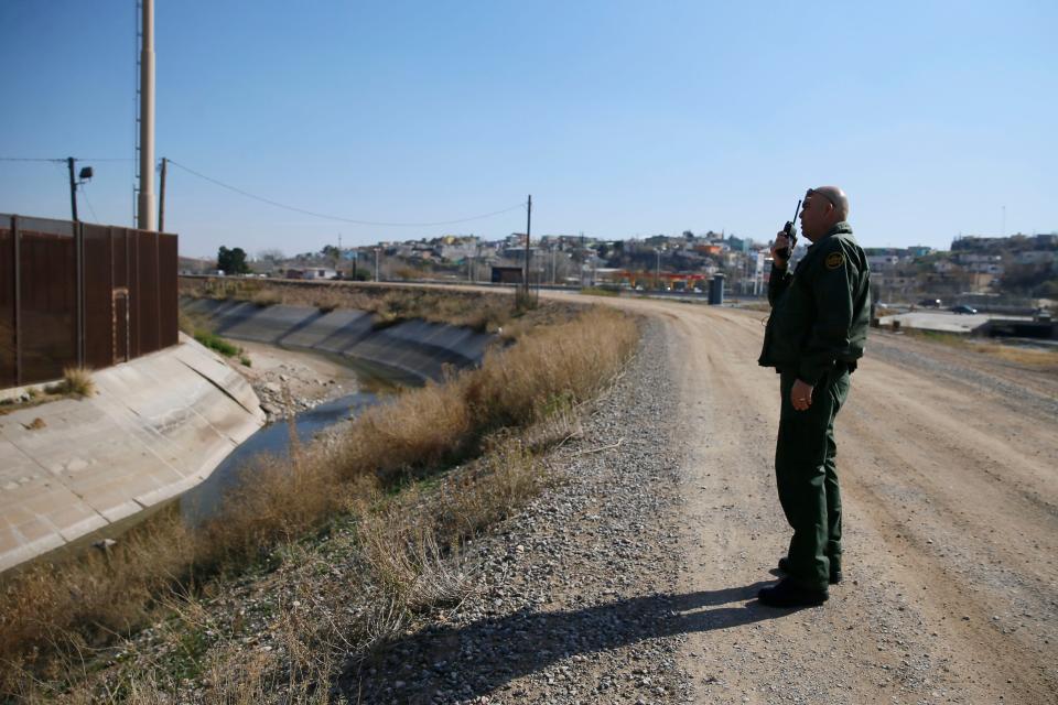 Border Patrol Agent Joe Romero notifies other agents about a makeshift ladder Feb. 13 in El Paso, Texas. Romero says the ladder looks like it was set out by someone during the day to get over the border fence that night.