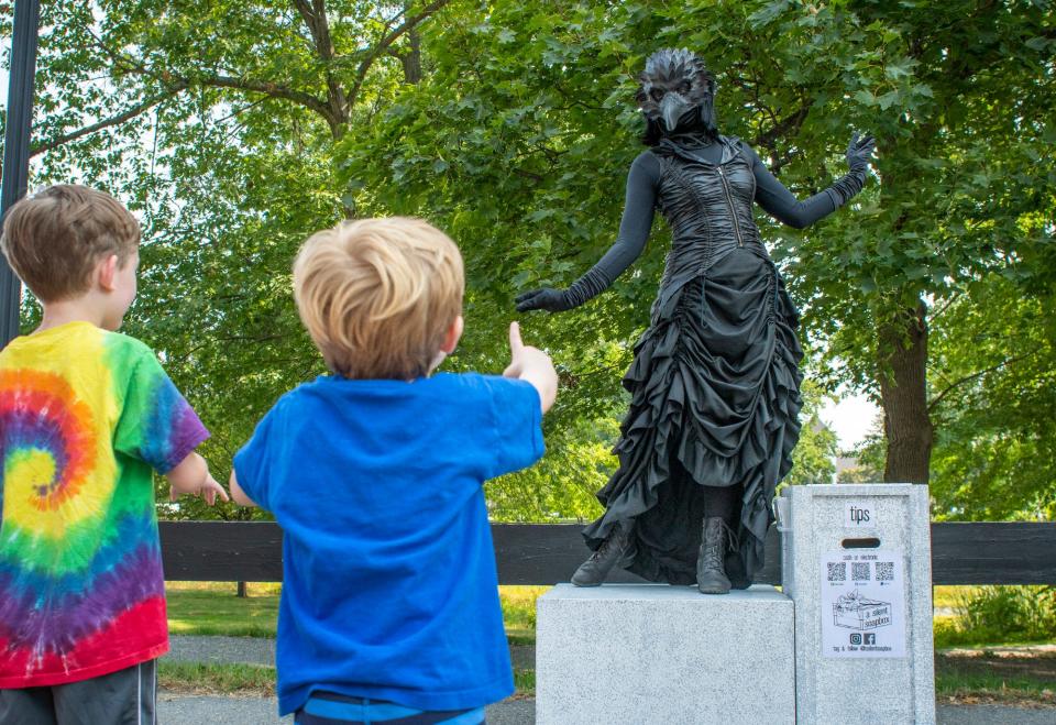 Children marvel at performance artist Tara Smith of Middleboro and her living statue of The Raven. Smith performs under the name "A Silent Soapbox."