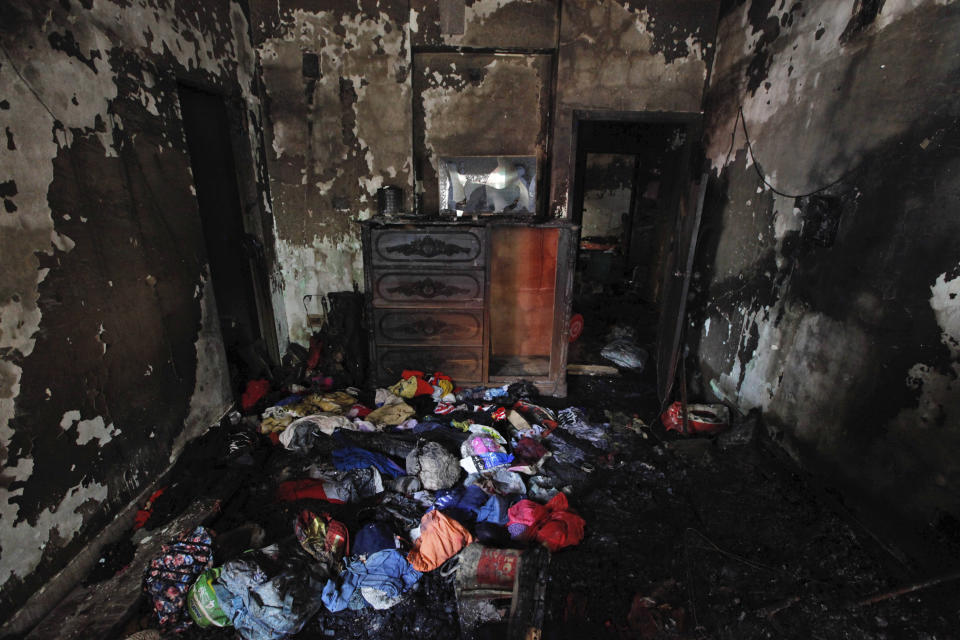 The burnt interior of a room is seen after a fire raced through the area on Wednesday night in Dhaka, Bangladesh, Friday, Feb. 22, 2019. Police on Friday were seeking up to a dozen suspects in connection with a fire in the oldest part of Bangladesh's capital that killed scores of people. (AP Photo/Mahmud Hossain Opu )