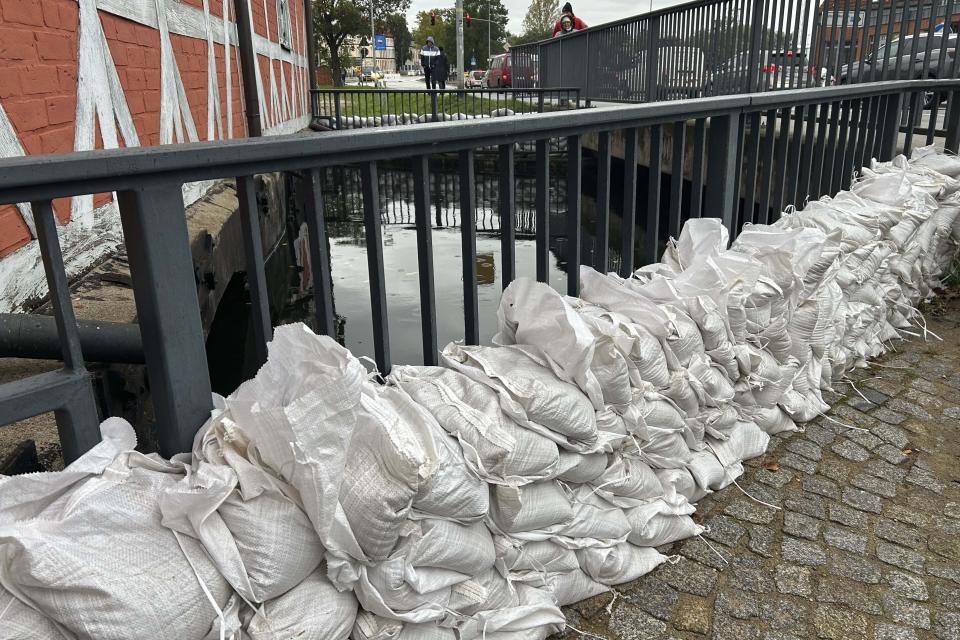 Stacked sandbags lie near the old town during heavy storm in Wismar at the Baltic Sea, Germany, Friday, Oct. 20, 2023. (AP Photo/Matthias Schrader)