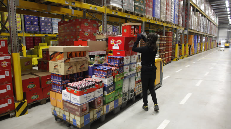 woman unloading packages Aldi warehouse